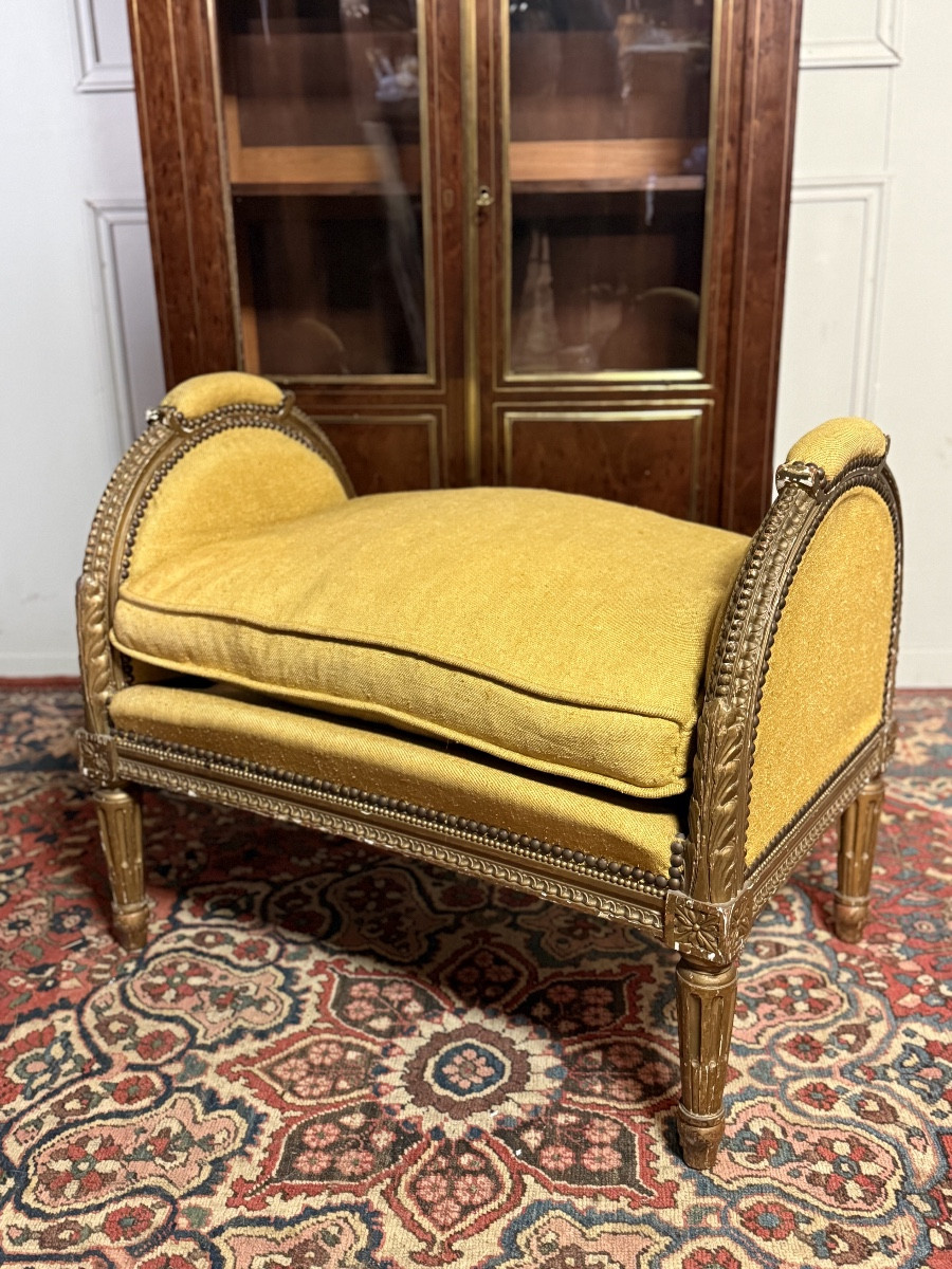 Banquette de style Louis XVI en bois doré.