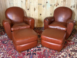 Paire de fauteuils club en cuir avec leurs repose-pieds